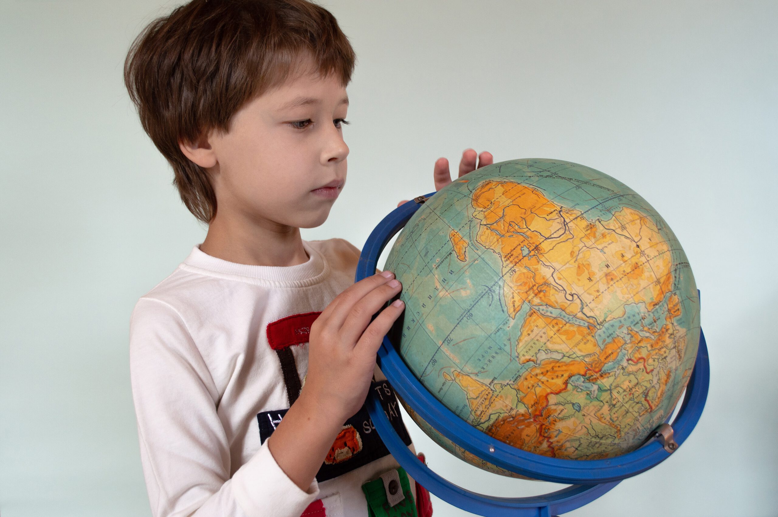 Chłopiec trzymający w ręce globus