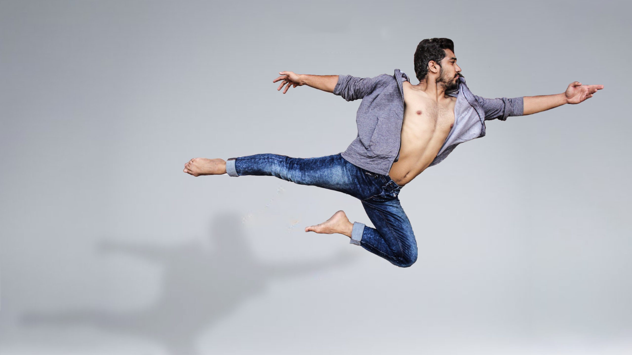 Tancerz podczas sesji zdjęciowej unoszący się w powietrzu na białym tle